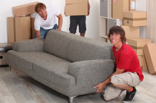 Staff wearing PPE while lifting furniture during a move