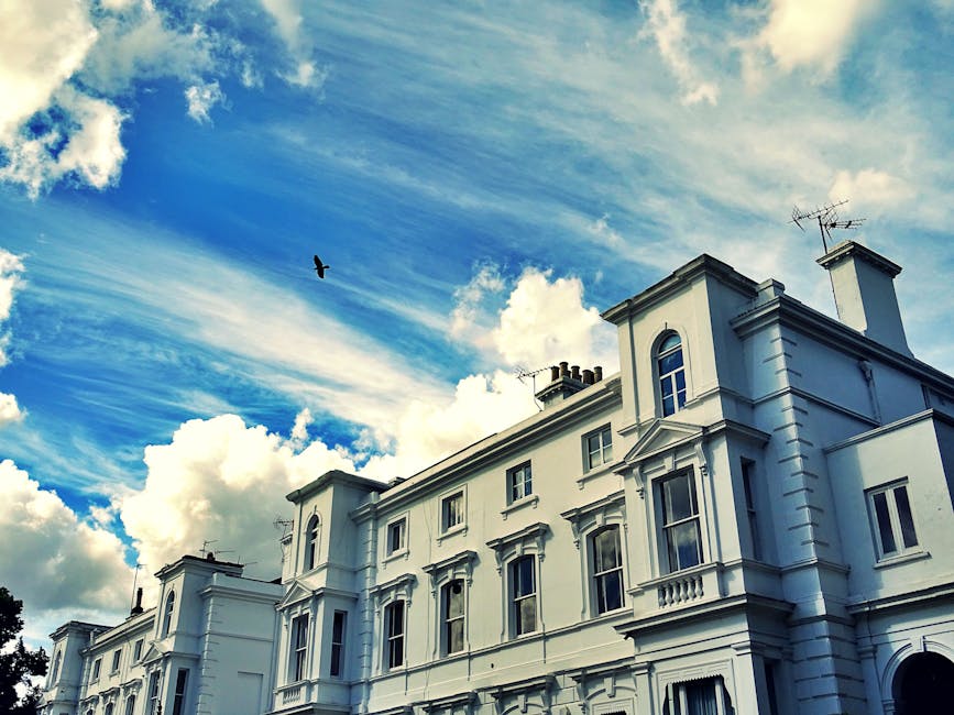 The exterior of a white, multi-storey Victorian-style building with ornate architectural details, including bay windows with decorative mouldings. The building's facade features three visible floors,